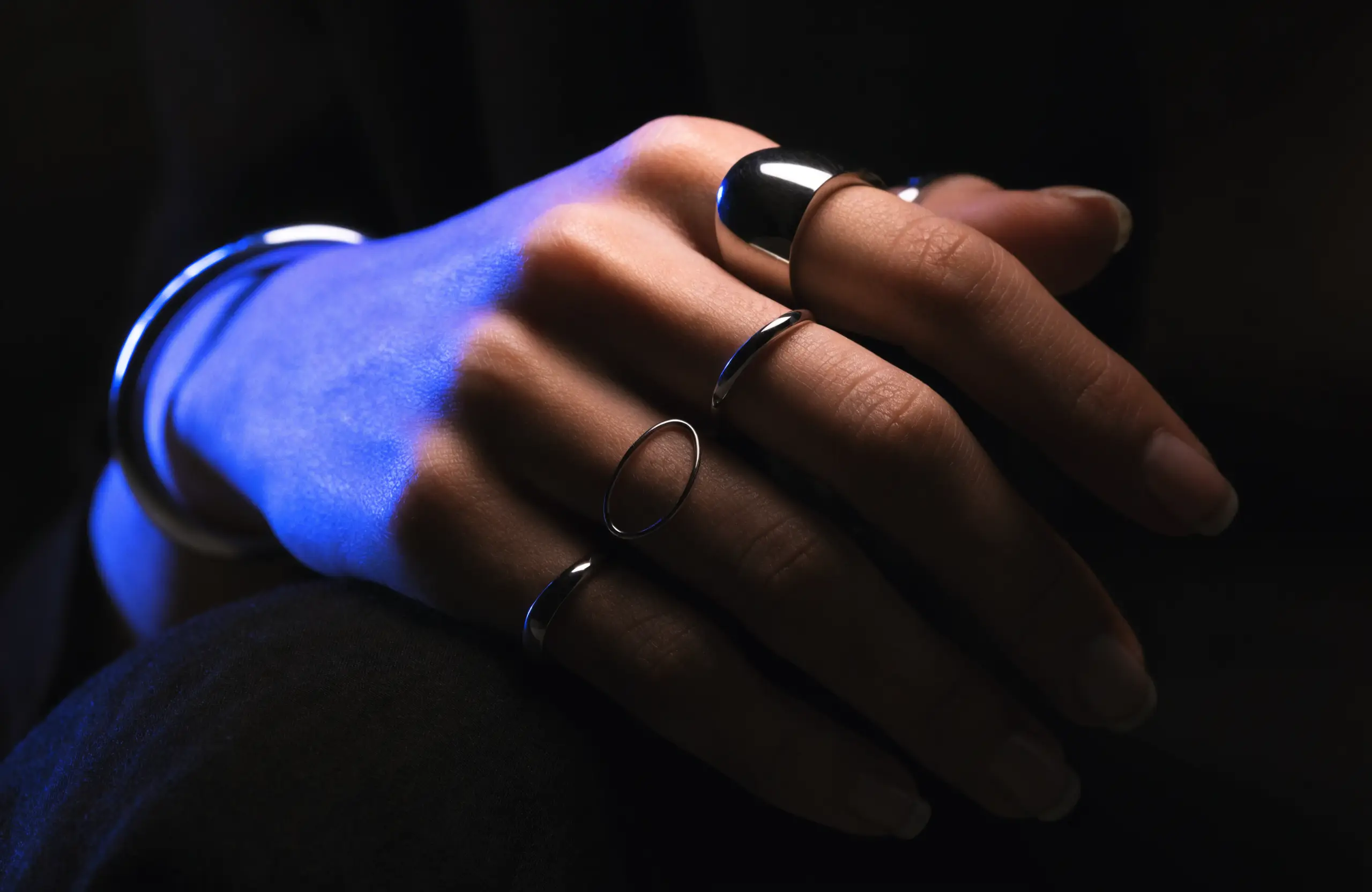 An elegant hand wearing premium minimalist rings and a bracelet