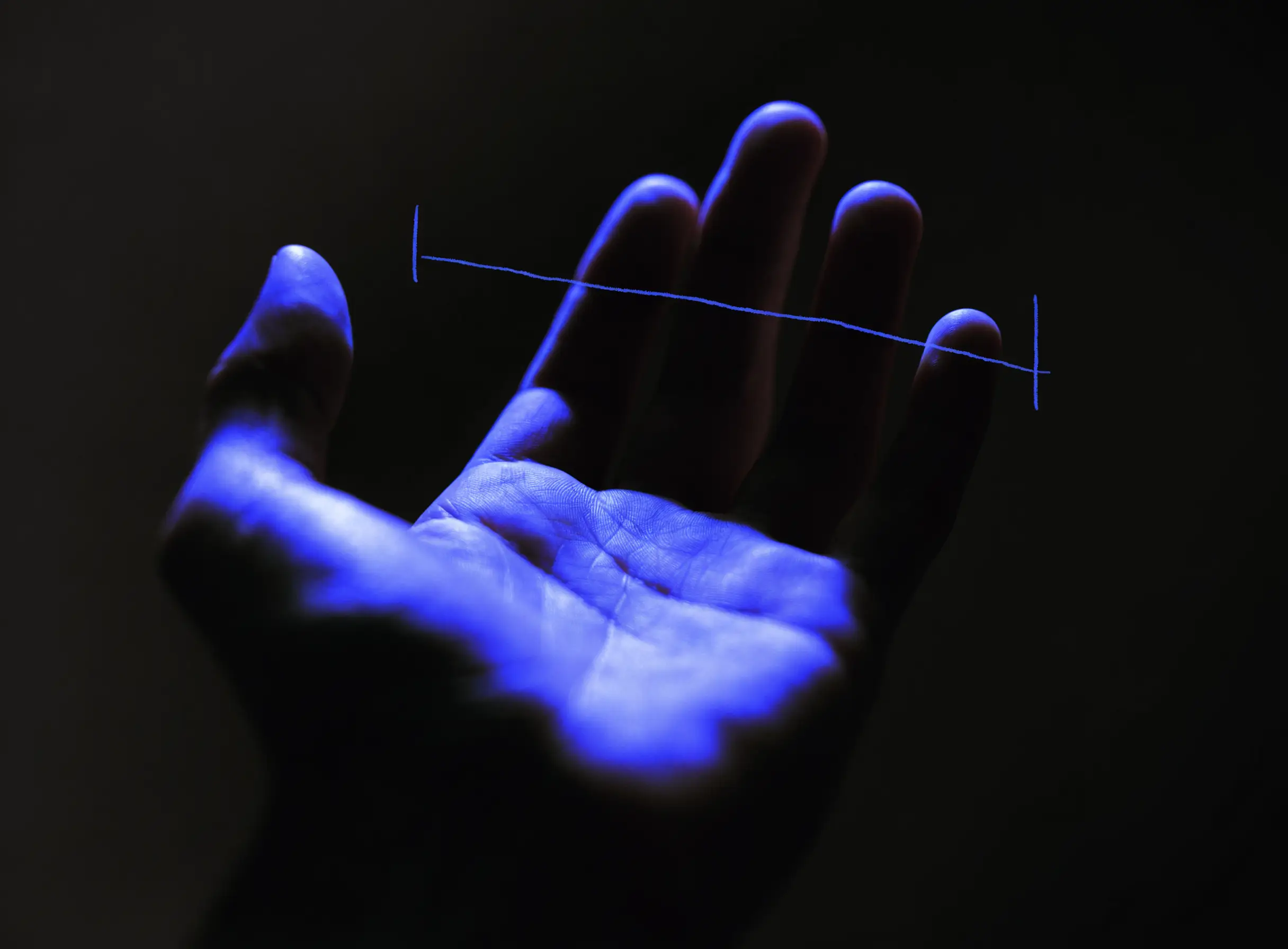 A single open human hand, palm forward, against a dark studio backdrop
