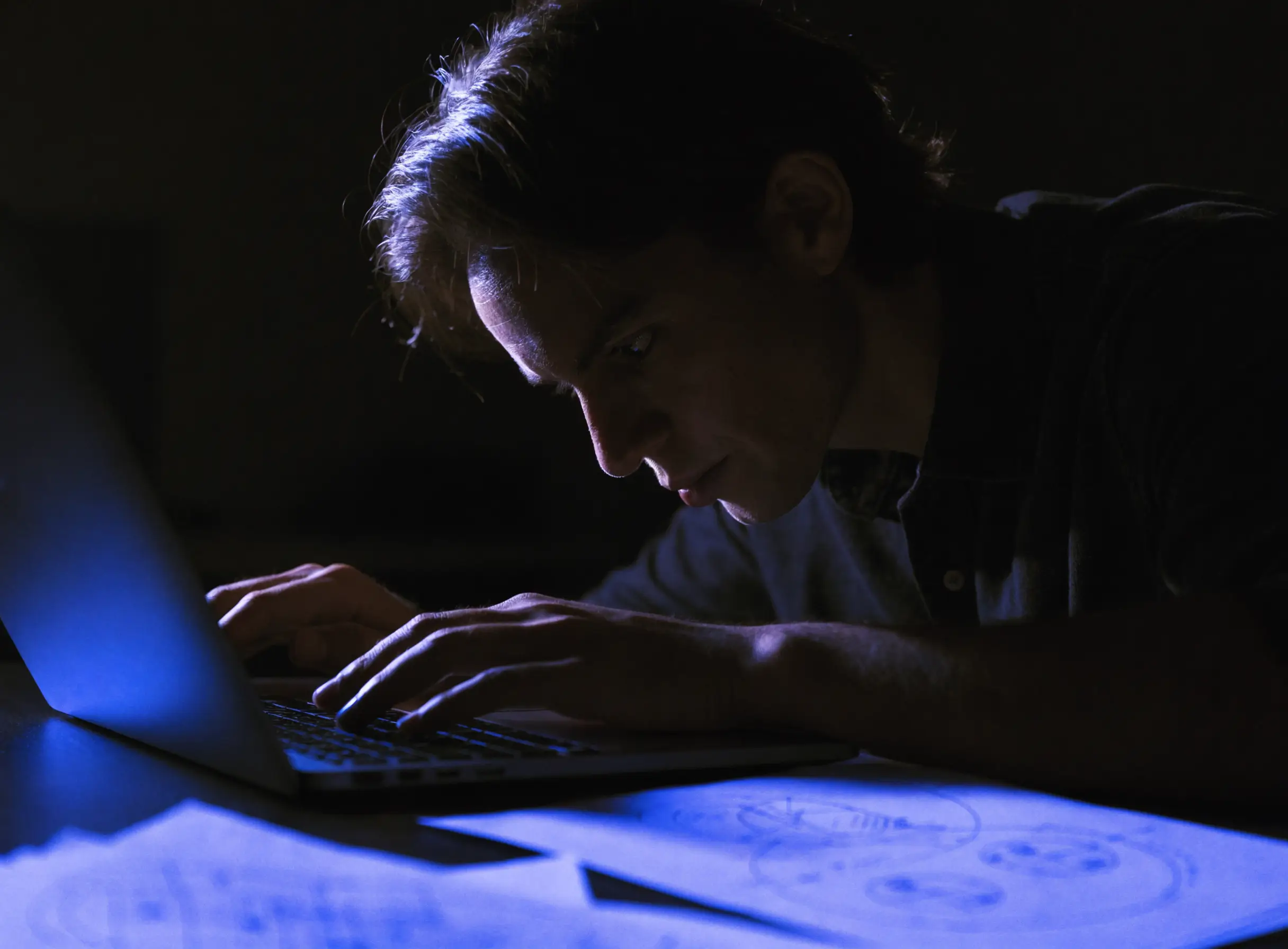 A person working intently in a dark studio, representing a founder-led build